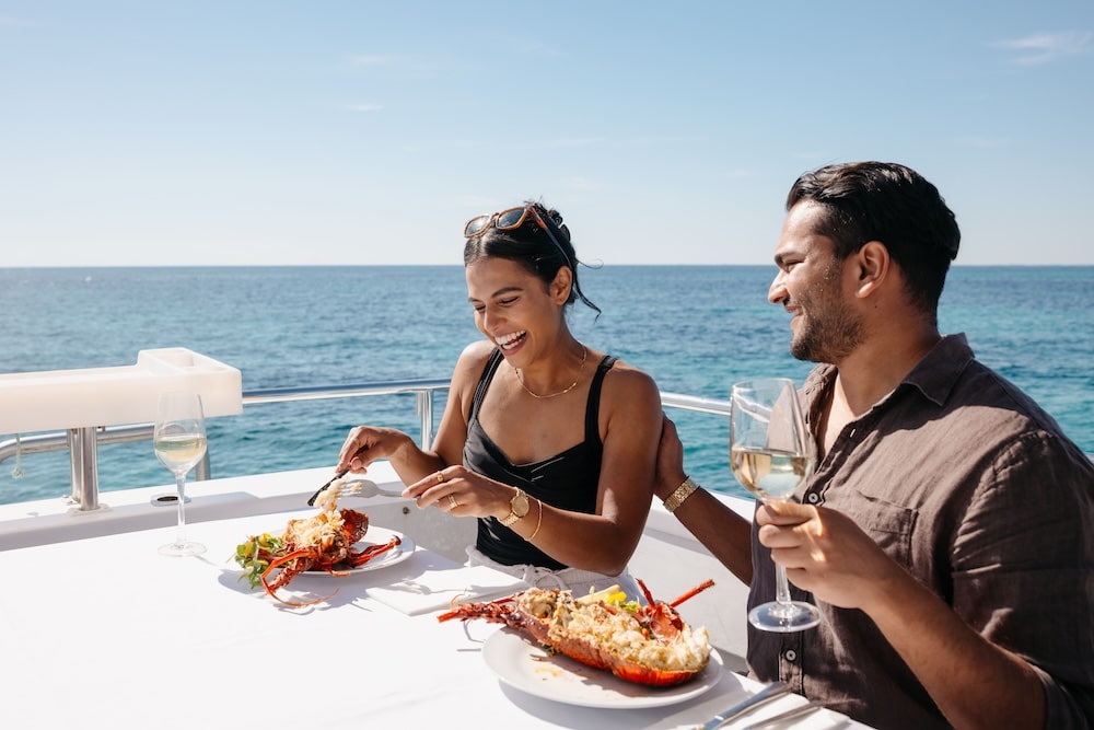 Two guests relaxing on a luxury cruise boat under the sun, featured in Yahoo! Life UK.